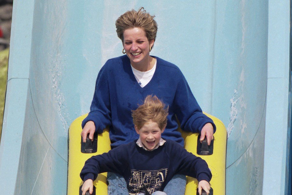 Color photo.  Woman and boy on a slide