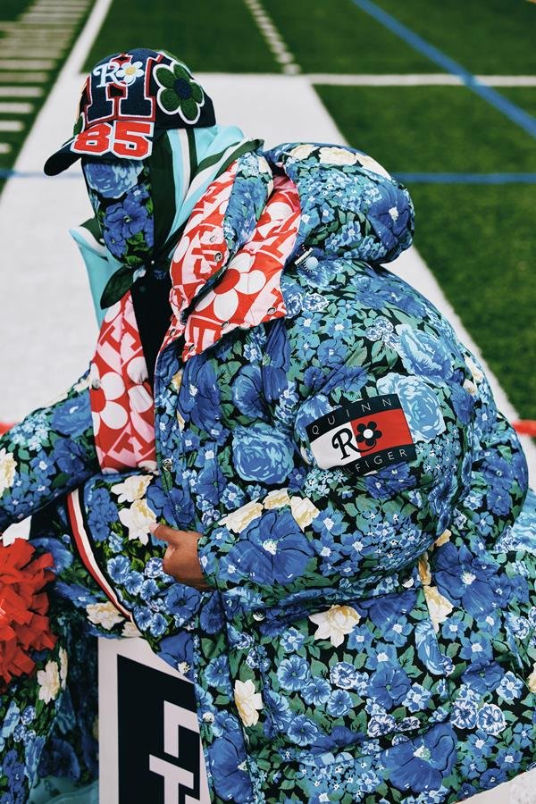 Fotos de campanha da coleção da Tommy Hilfiger com o estilista Richard Quinn. Uma pessoa não identificada aparece com com o rosto coberto por uma máscara com uma estampa de flores azuis. Essa mesma estampa está no casaco e na calça.