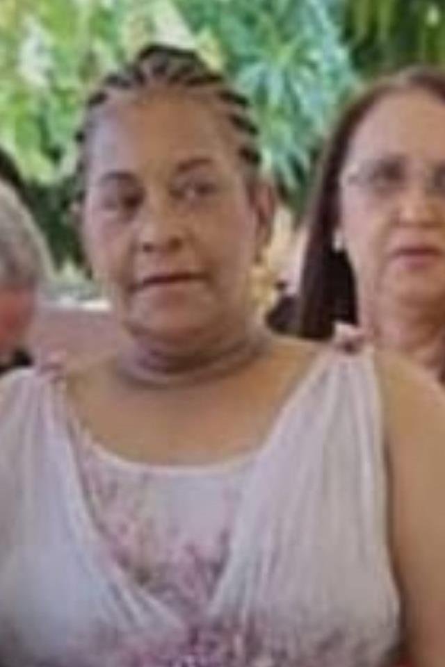 foto de solange bento usando vestido rosa-claro, cabelo preso para trás e com uma mulher ao fundo