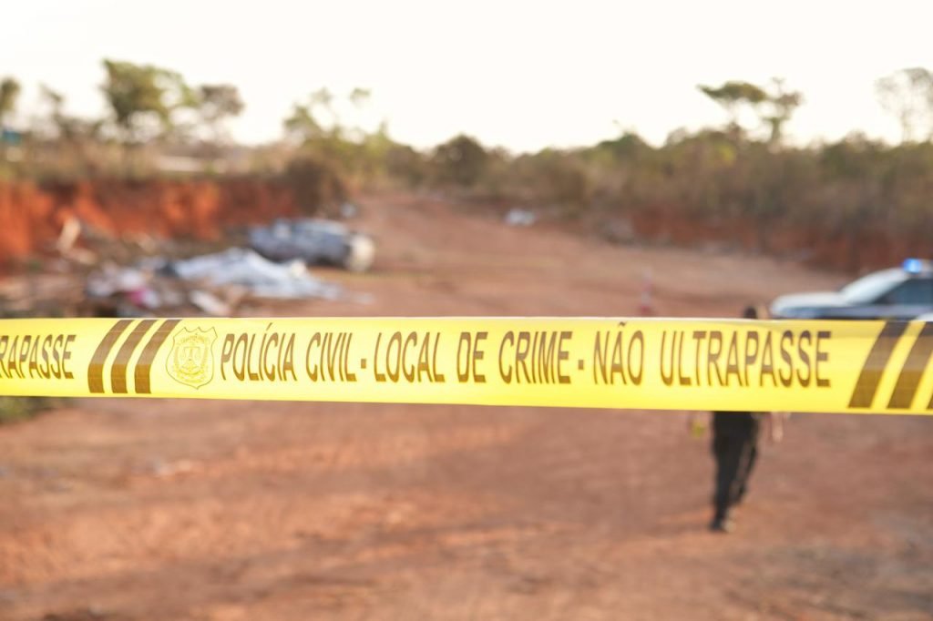 Fita amarela em frente a terreno de barro
