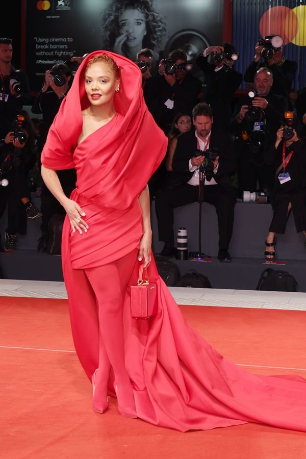 Na imagem com cor, mulher usa vestido vermelho no Festival de Veneza 2022