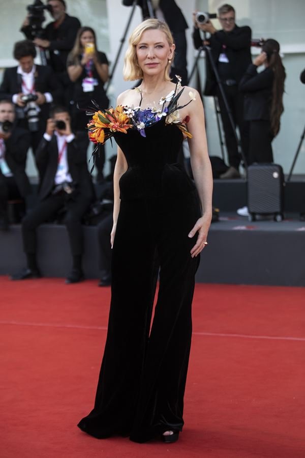 Na imagem com cor, mulher usa vestido preto no Festival de Veneza 2022 
