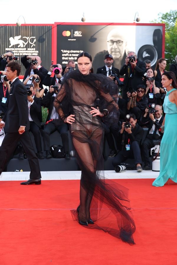 Na imagem com cor, mulher usa vestido preto no Festival de Veneza 2022 