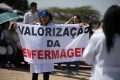 Profissional segura cartaz e pede valorização da enfermagem