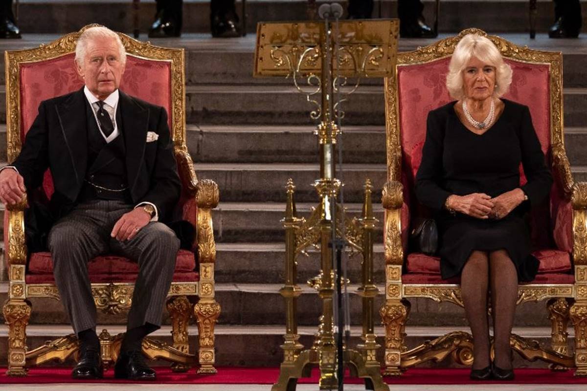 color photo of an old man and an old woman sitting on thrones