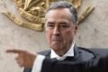 mão aponta em direção oposta ao ministro Luís Roberto Barroso