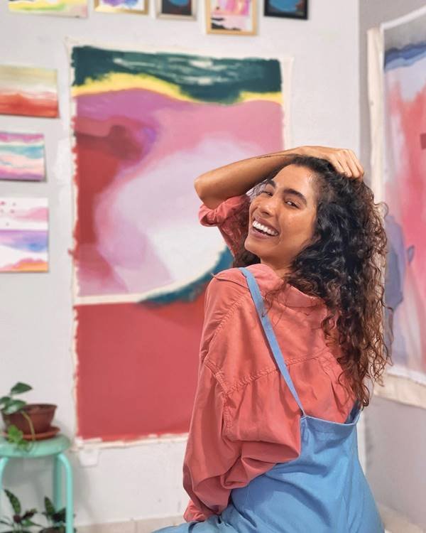 Isadora Maia posando em frente a painel 