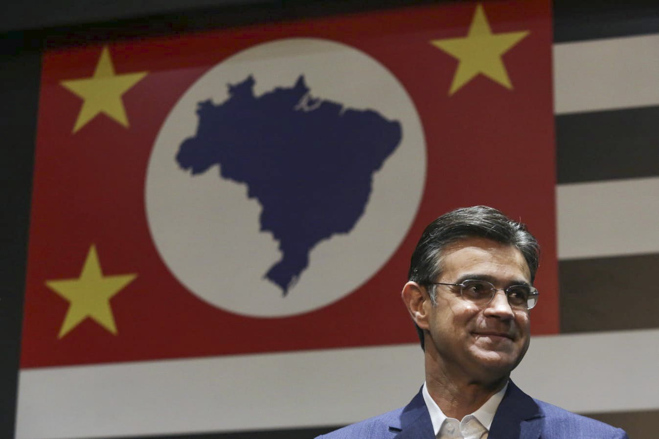 Governador, candidato a reeleição, Rodrigo Garcia (PSDB) ao fundo a bandeira do estado de são paulo