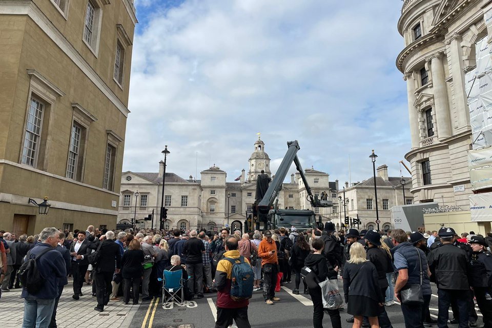 Público, sentado e em pé, em rua próxima ao Palácio de Westminster, onde aguardam pela chegada do caixão da rainha Elizabeth II