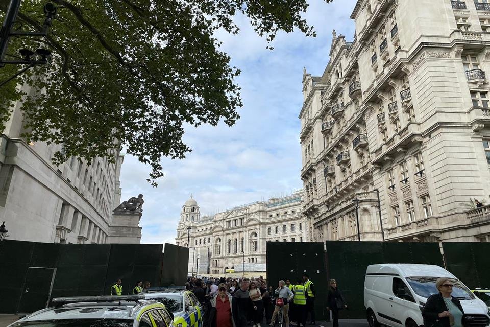 Rua de Londres próxima ao Palácio de Westminster, onde público, polícia e veículos se concentram até a chegada do caixão da rainha Elizabeth II