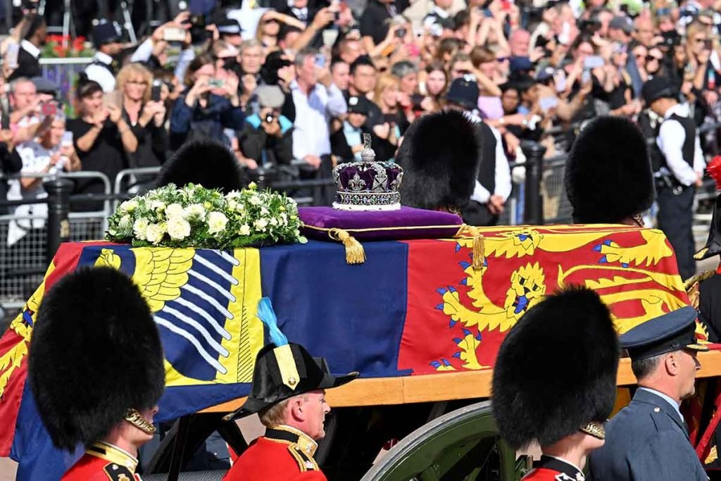 O caixão carregando a Rainha Elizabeth II percorre o The Mall durante a procissão para o Estado Deitado da Rainha Elizabeth II em 14 de setembro de 2022 em Londres, Inglaterra. O caixão da rainha Elizabeth II é levado em procissão em uma carruagem da tropa real de artilharia do rei, do Palácio de Buckingham ao Westminster Hall, onde ela ficará em estado até o início da manhã de seu funeral. A rainha Elizabeth II morreu no Castelo de Balmoral, na Escócia, em 8 de setembro de 2022, e é sucedida por seu filho mais velho, o rei Carlos III