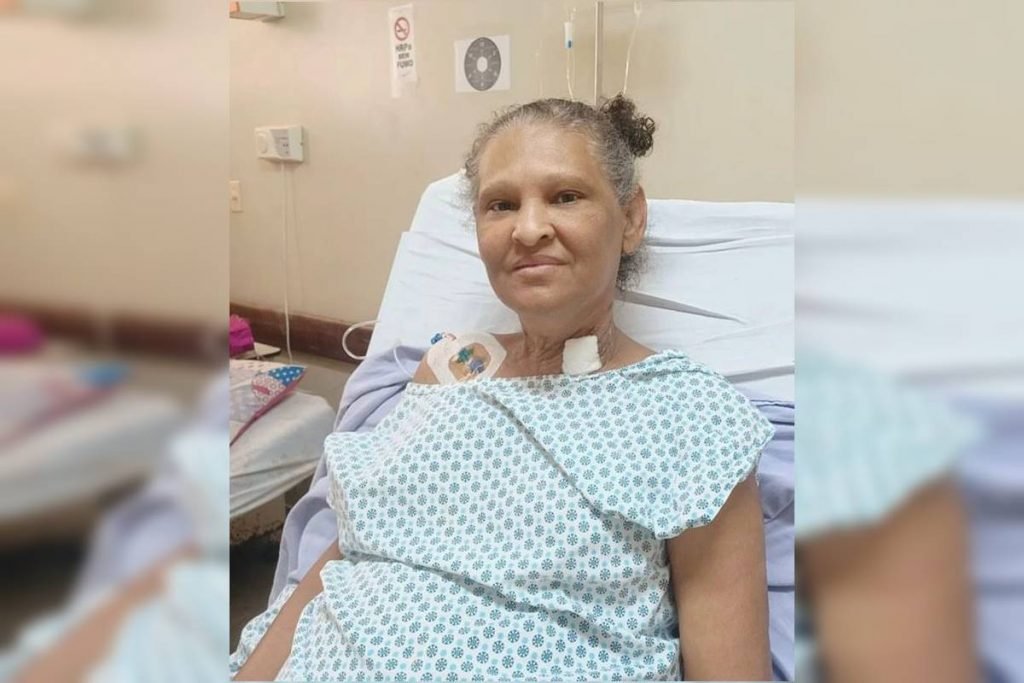 Mulher sentada em cama de hospital