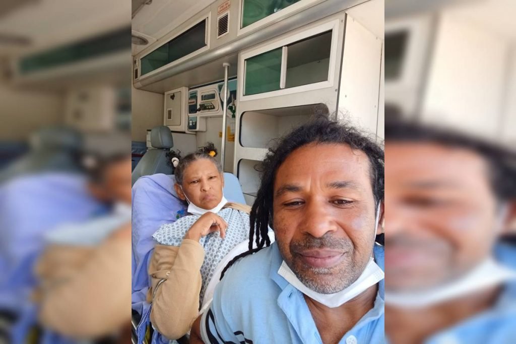 Esposa e marido com roupa azul dentro de ambulância