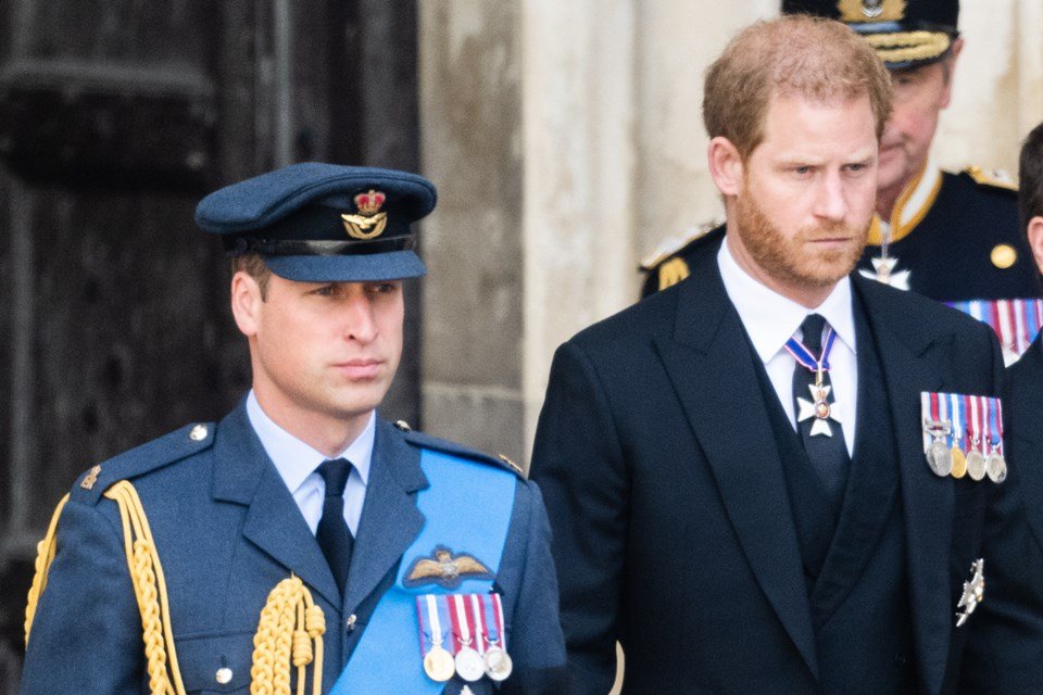 Os irmãos e príncipes William e Harry seguem o caixão da rainha Elizabeth II em seu velório. William usa farda e quepe e Harry veste terno - Metrópoles