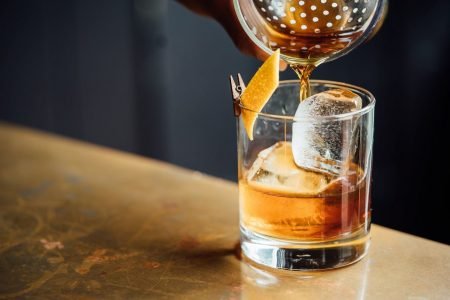 Drinque Old Fashioned servindo servido por bartender - Metrópoles
