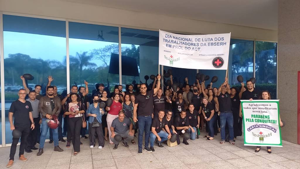 Trabalhadores do Hospital Universitário de Brasília (HUB) entram em greve e protestam na entrada da insituição, vestidos de preto e levantando cartazes - Metrópoles