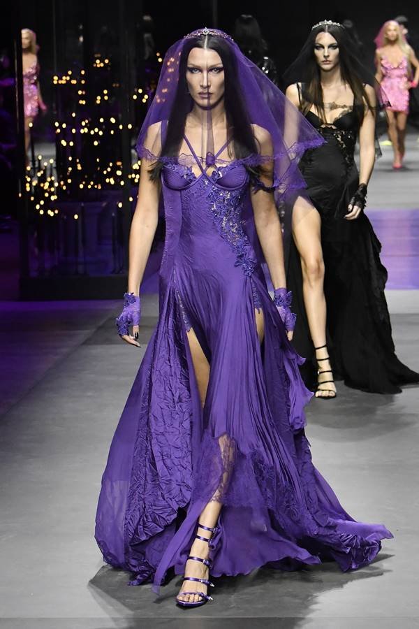 Bella Hadid usando vestido roxo com véu no rosto, na passarela da Versace