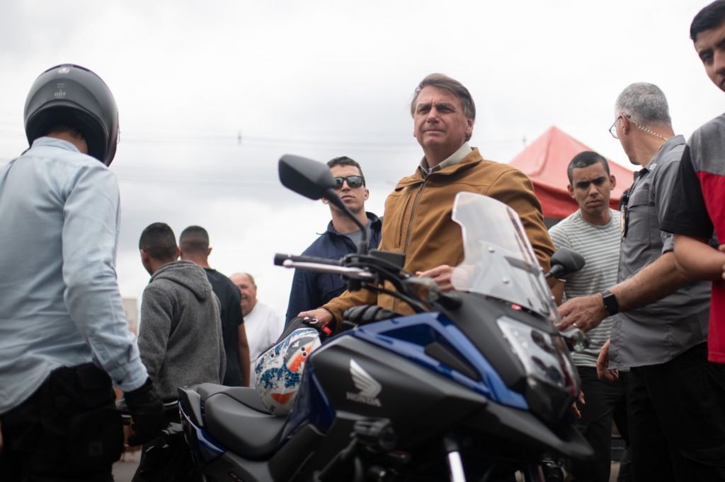 O presidente Jair Bolsonaro comendo churrasquinho em uma barraca no Guará, no DF