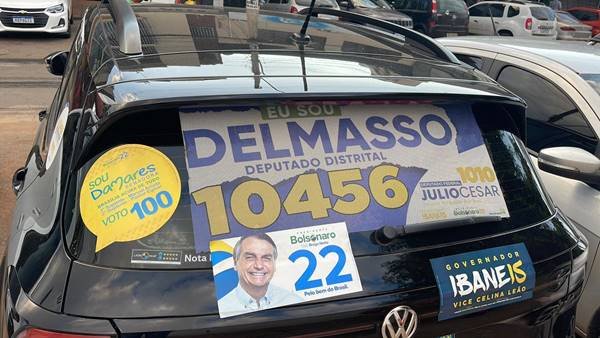 Fotografia colorida de traseira de veículo com adesivo de candidatos