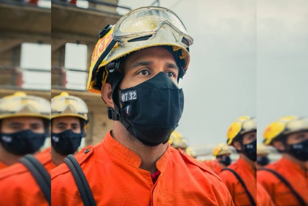 Soldado Anderson Araujo Costa Bomfim em pé de uniforme laranja e máscara
