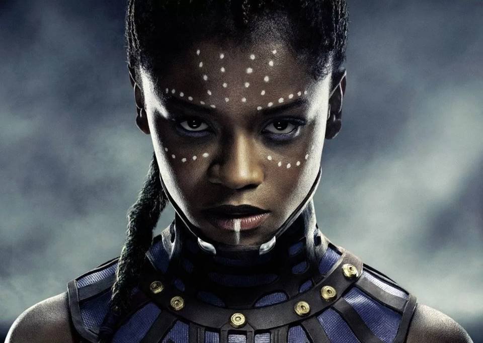 Na foto, Shuri em Pantera Negra: Wakanda Forever. Ela usa uma armadura preta, cabelo amarrado, pele negra, maquiagem com pontinhos brancos no rosto - Metrópoles