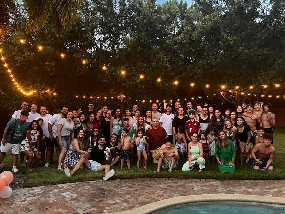 Pessoas unidas para foto em local com árvores e luzes
