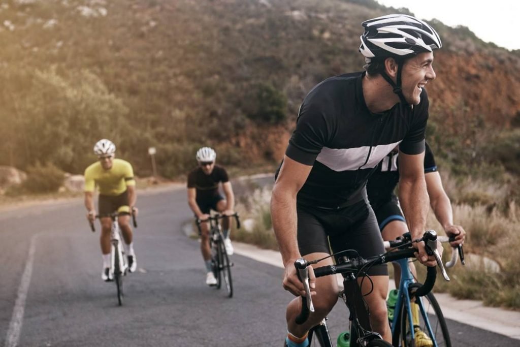 foto colorida de pessoas andando de bicicleta