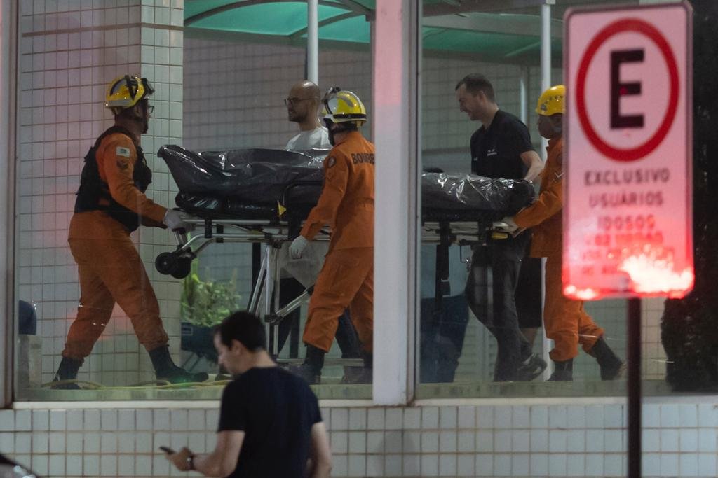 Bombeiro transporta o corpo da vítima