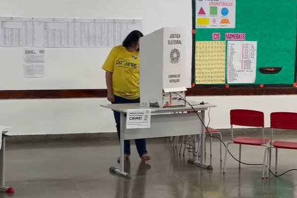 Fotografia colorida de mulher votando em urna eletrônica