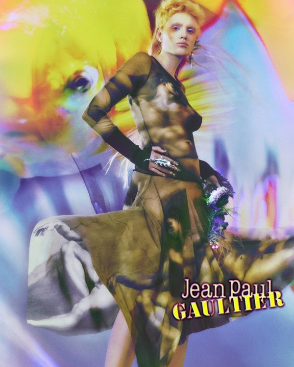 Campanha de divulgação da marca Jean Paul Gaultier, onde uma modelo branca, jovem e com uma peruca de cabelos lisos amarelos aparece com peças em homenagem ao quadro A Criação de Adão, de Michelangelo