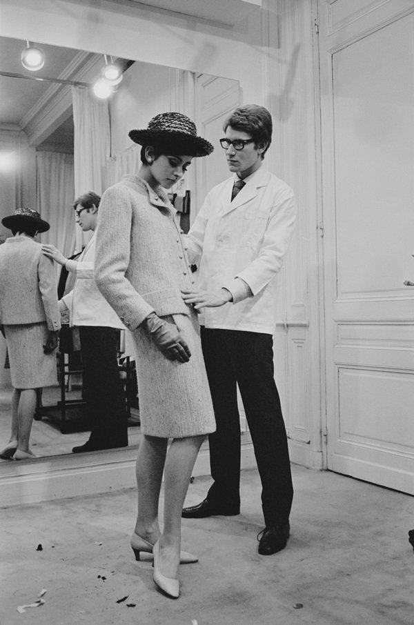 Yves Saint Laurent, ex-estilista da marca francesa Dior, trabalhando com uma modelo em sua própria casa de moda em Paris, em 1965 - Metrópoles