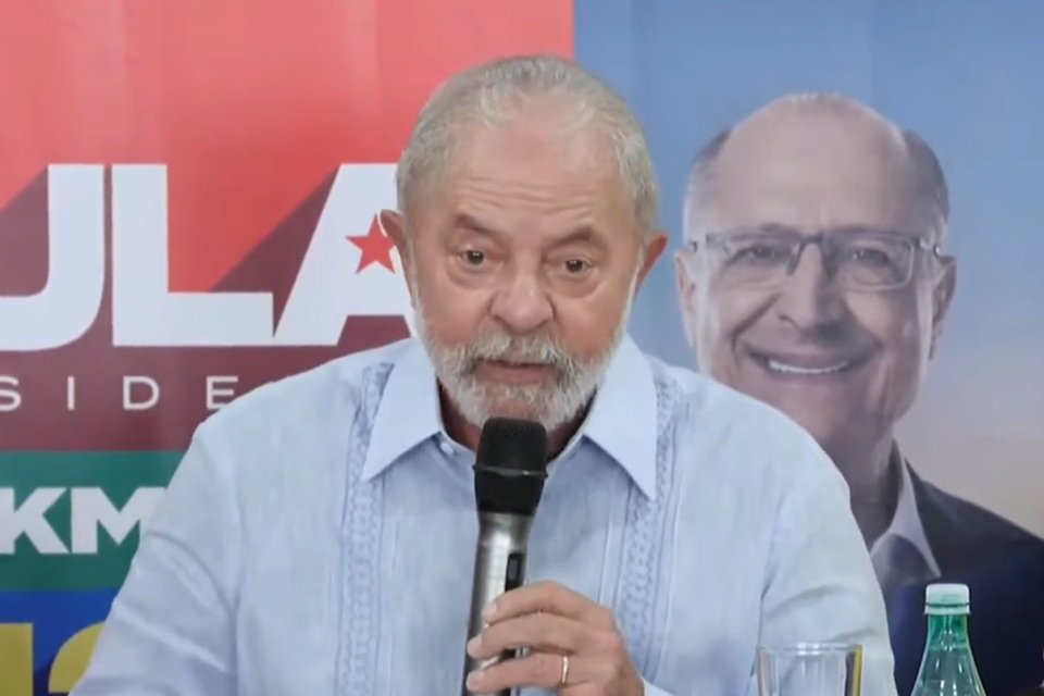 Ex-presidente e candidato à presidência Lula discursa em Recife. Na foto, frente a banner da campanha, ele segura um microfone e usa camisa azul clara - Metrópoles