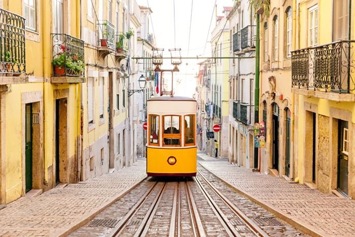 Imagem colorida de bondinho amarelo em Portugal - Metrópoles