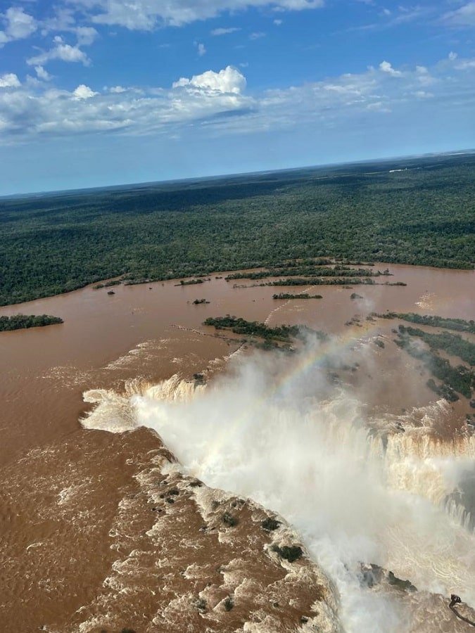 Foto mostra cheia nas Cataratas do Iguaçu, na fronteira entre o Paraná e a Argentina, com fortes ondas de água de coloração amarronzada - Metrópoles