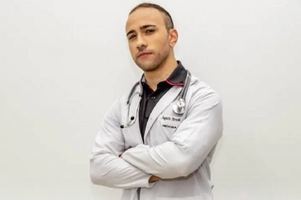 Jovem branco com jaleco de médico