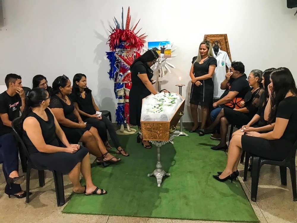 foto colorida de alunos simulando funeral com caixão e flores