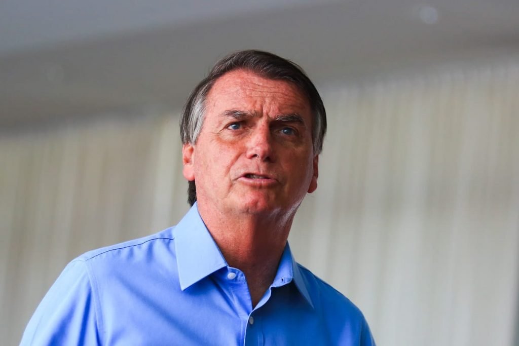 O presidente e candidato à reeleição Jair Bolsonaro caminha no Planalto em ato com apoio de políticos goianos. Ele usa camisa azul com adesivo de campanha - Metrópoles