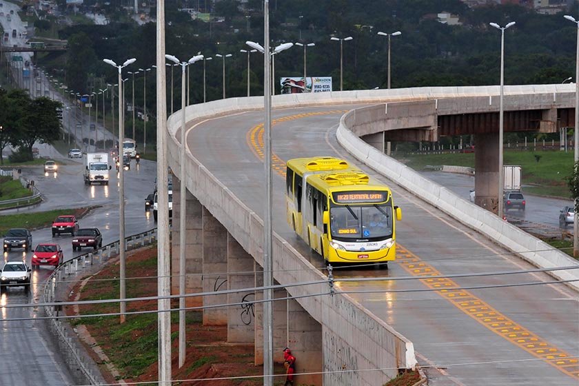 Ônibus amarelo BRT passando em viaduto cercado de outras pistas abaixo - Metrópoles