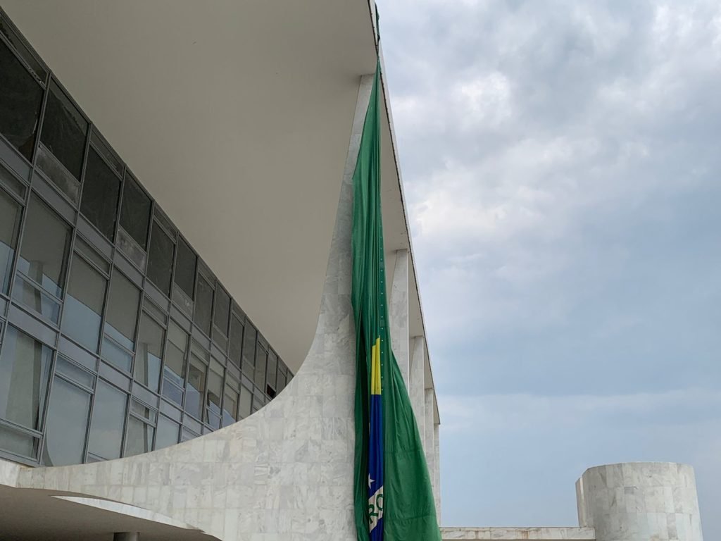 Bandeira nacional gigante estendida sob fachada do Palácio do Planalto aparece resgada - metrópoles
