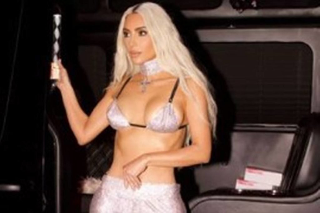 Kim Kardashian usa cabelo loiro, top de brilho e calça de brilho - Metrópoles