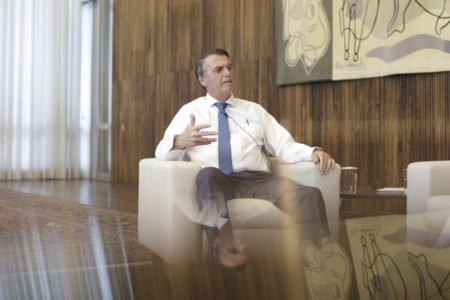 Presidente é Bolsonaro entrevistado pela jornalista Lilian Tahan, do portal Metrópoles. Ambos estão sentado em salão amplo do palácio da Alvorada e o presidente fala gesticulando - Metrópoles