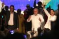 Fernando Haddad e Janja fazem o L de Lula com as mãos durante evento em são paulo