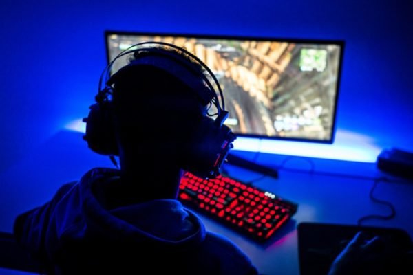 Jovem adulto jogando estratégia de videogame em casa, se