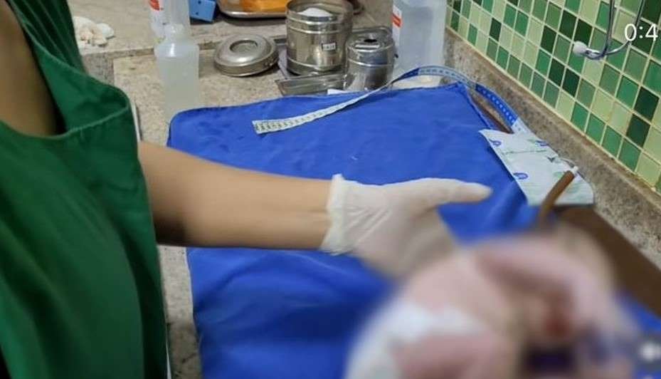 Em post no Instagram, médico pede votos em Bolsonaro durante parto. Na foto, enfermeira manuseia bebê recém-nascido sob pano azul - Metrópoles