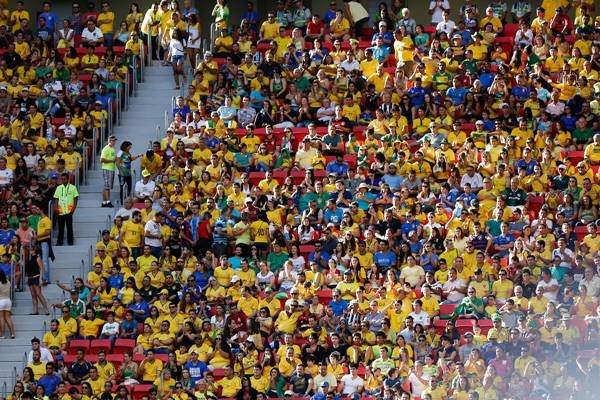 Fotografia colorida de torcida em arquibancada