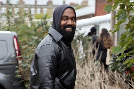 Imagem de Kanye West sorrindo para foto - Metrópoles