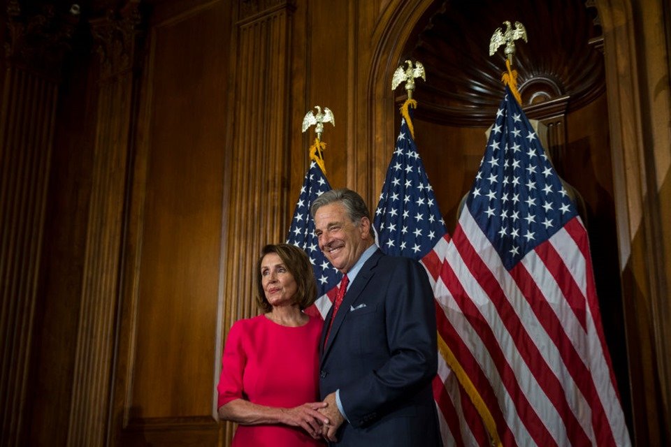 Nancy e Paul Pelosi posam para foto em frente a bandeiras dos Estados Unidos - Metrópoles