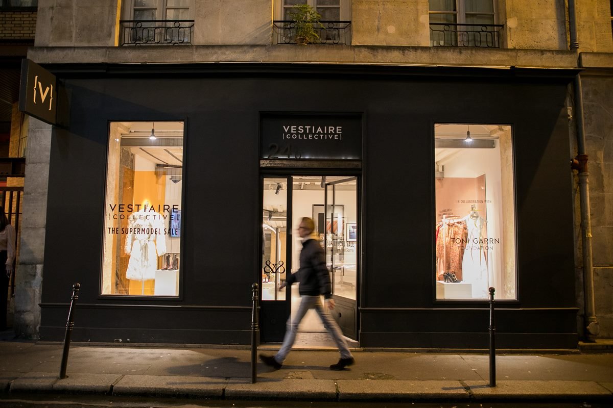 Vitrine da loja Vestiaire Collective, um brechó de luxo, em Paris, na França. Na foto é possível ver manequins com roupas e prateleiras com produtos como bolsas e calçados. - Metrópoles