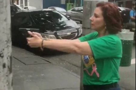 imagem colorida da deputada carla zambelli apontando arma e de camisa verde