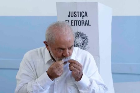 Lula beijando o comprovante de votação- Metrópoles